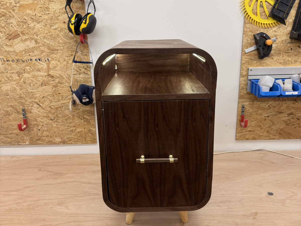 Curved nightstand — black walnut veneer — Soft radius, deep colours.